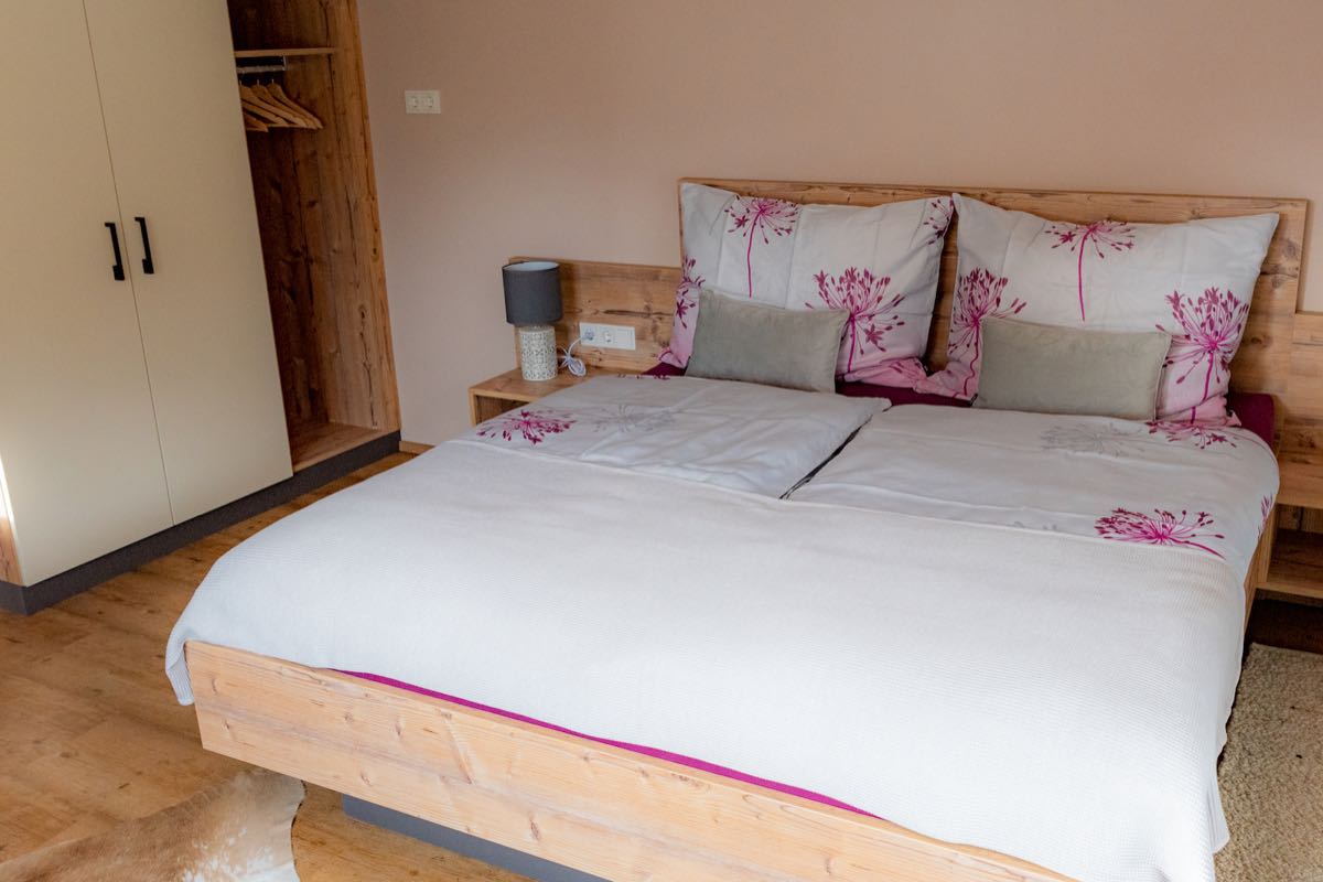 Doppelbett mit Landhaus-Bettwäsche – Schlafzimmer 1