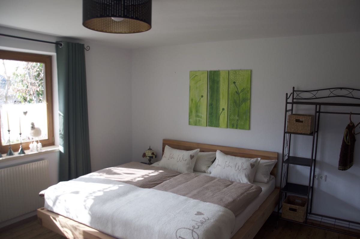 Gemütliches Doppelbett mit Ausblick in den Garten. – Schlafzimmer 2